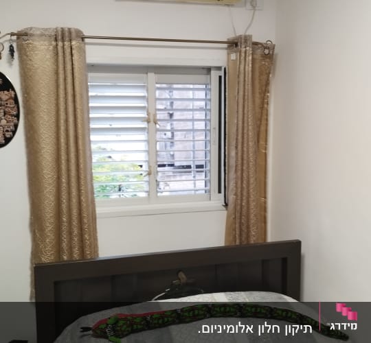 תריסים לבנים פתוחים בחלון חדר שינה